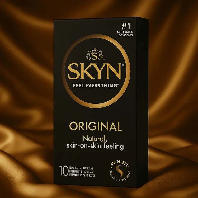 SKYN Original kondomer i elegant sort og gylden emballage placeret på gyldent satinunderlag; billede til SKYN kondomer kollektionen hos Nevola, som fremhæver latexfri komfort, naturlig følelse og tryg intimitet for både kvinder og mænd.