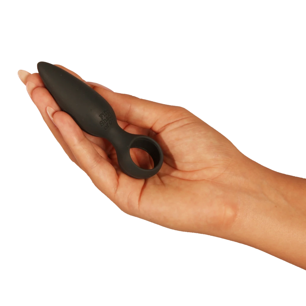 Fifty Shades of Grey silikone butt plug vist i en kvindes hånd; lille, begyndervenlig størrelse med konisk form og rund base, fremstillet i kropssikker silikone til blid, tryg og kontrolleret anal stimulering.