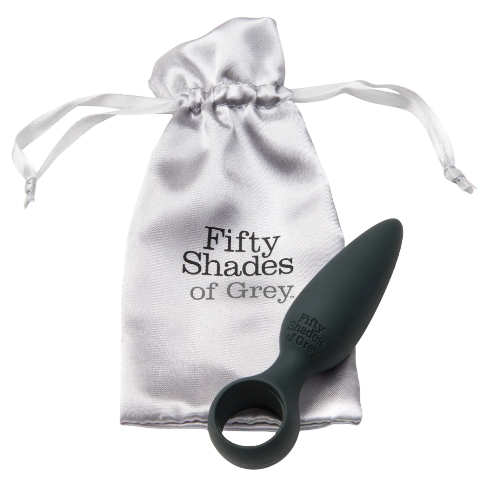 Fifty Shades of Grey silikone butt plug med rund base vist sammen med elegant sølvfarvet opbevaringspose i satin med logo; begyndervenligt sexlegetøj designet til tryg, sanselig og diskret nydelse med luksuriøs finish.