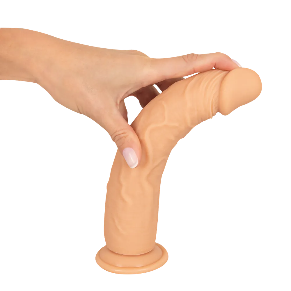 Fleksibel realistisk dildo bøjet med hånden for at vise materialets smidighed