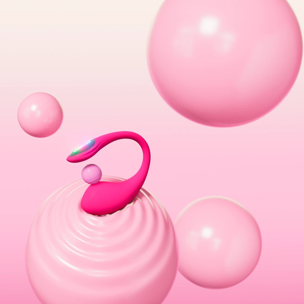 Lovense Lush 4 præsenteret i kunstnerisk pink univers med flydende bobler. Vibratorægget fremstår moderne, sanseligt og elegant med LED-lys, og understreger den feminine og legende oplevelse af app-styret nydelse.