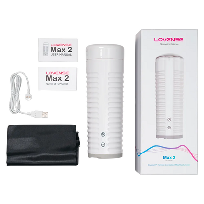 Lovense Max 2 masturbator vist sammen med alt tilbehør i pakken, herunder USB-kabel, opbevaringspose og manualer. Billedet viser hvad der følger med i kassen til app-styret sexlegetøj til mænd.
