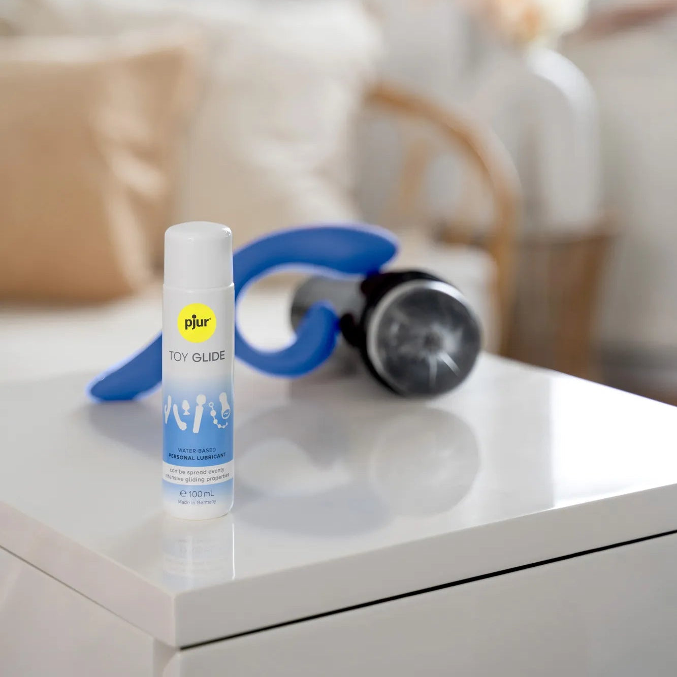 Pjur Toy Glide vandbaseret glidecreme i 100 ml flaske fotograferet i hjemlig setting. Skånsom formel designet til sexlegetøj, giver glat og behagelig oplevelse med naturlig følelse i intime øjeblikke.