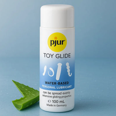 Pjur Toy Glide vandbaseret glidecreme 100 ml stående på blå vandoverflade med aloe vera blad, ideel til brug med erotisk legetøj og nem at fordele for intens glidning.