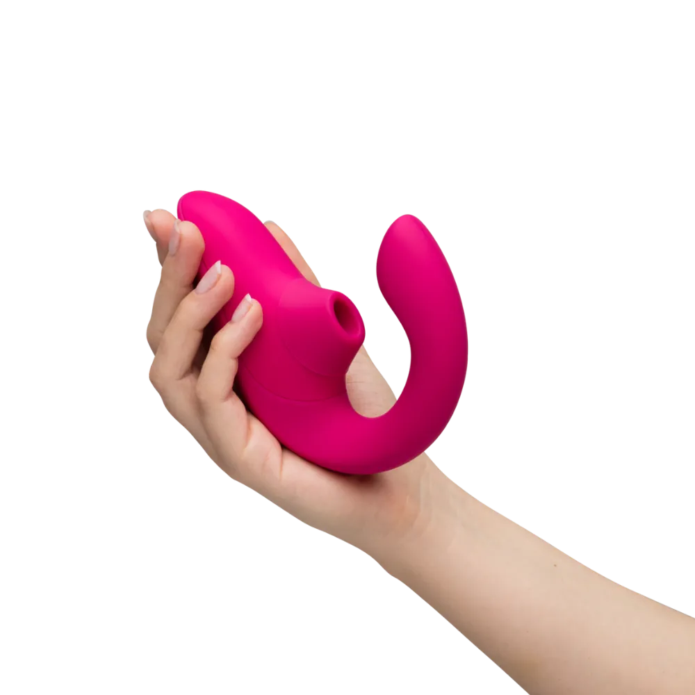 Kvinde holder Womanizer Blend sexlegetøj i hånden. Billedet viser lufttryksvibratorens ergonomiske design, buede form og klitorisstimulator til sanselig stimulering og diskret selvforkælelse.