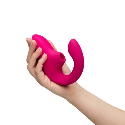 Kvinde holder Womanizer Blend sexlegetøj i hånden. Billedet viser lufttryksvibratorens ergonomiske design, buede form og klitorisstimulator til sanselig stimulering og diskret selvforkælelse.