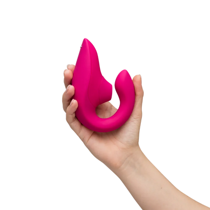 Womanizer Blend lufttryksvibrator i pink holdt i en kvindes hånd. Lifestylebillede der illustrerer sexlegetøjets størrelse og design.