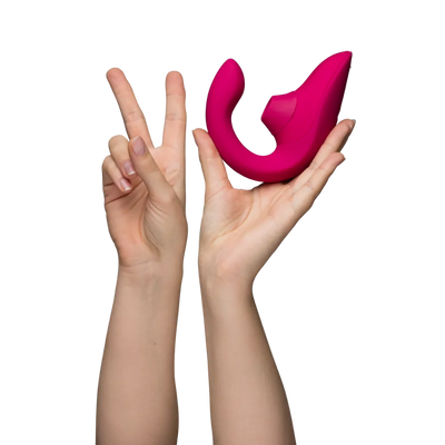 Kvinde holder Womanizer Blend sexlegetøj i hånden for at vise størrelse og ergonomisk design. Billedet illustrerer lufttryksvibratorens kompakte form og buede vibrationsdel.