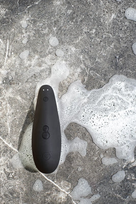 Womanizer Classic 2 lufttryksvibrator i sort placeret i skummende vand. Vandtæt lufttryksvibrator til kvinder, skabt til intens nydelse, wellness og tryg brug i bad og bruser.
