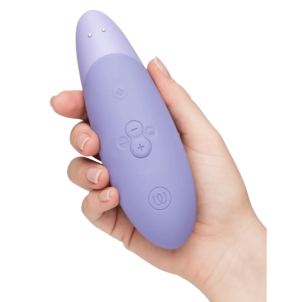 Womanizer Enhance i farven lilac holdt i hånden med tydeligt fokus på de intuitive kontrolknapper – designet til nem betjening, blid stimulering og personlig nydelse i dit eget tempo.