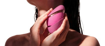 Womanizer Next Liberty med beskyttelsescover vist tæt på kroppen i varmt lys
