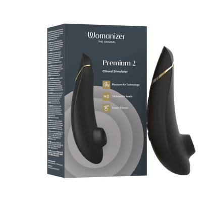 Womanizer Premium 2 clitoral stimulator i sort med gyldne detaljer ved siden af sin originale æske. Eksklusivt intimprodukt med Pleasure Air Technology og 14 niveauer af intens stimulering.